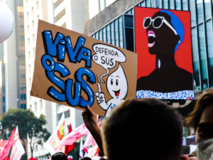 a group of people holding up signs in the air — Foto por Tutz Dias na Unsplash