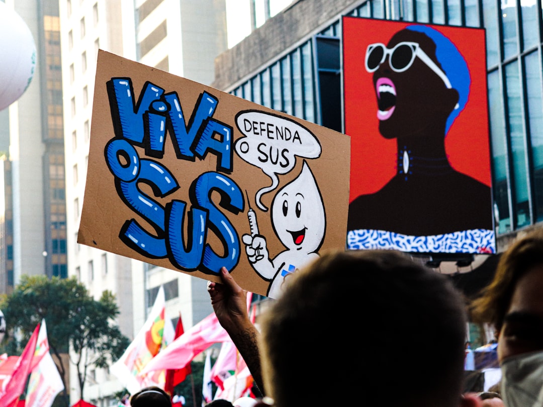 a group of people holding up signs in the air — Foto por Tutz Dias na Unsplash