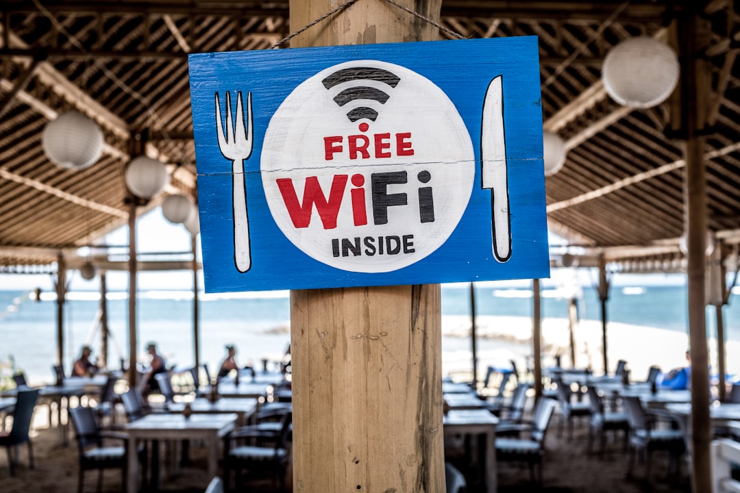 Free WiFi signage on wooden post — Foto por Bernard Hermant na Unsplash
