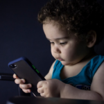 boy in blue tank top holding black iphone 5 — Foto por hessam nabavi na Unsplash