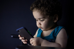 boy in blue tank top holding black iphone 5 — Foto por hessam nabavi na Unsplash