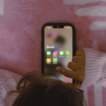 a person laying in bed holding a cell phone — Foto por Sanket Mishra na Unsplash